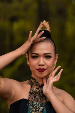 Beautiful face of a Javanese woman in a traditional dance costume before the dance performance begins inside the festival