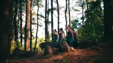 Bir grup Endonezyalı kadın gün ışığında köydeki festivalde gösteri yaparken yeşil elbiseler içinde dans ediyorlar.