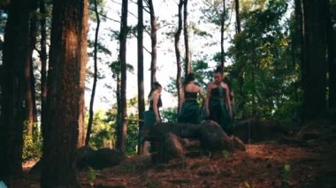 Bir grup Endonezyalı kadın gün ışığında köydeki festivalde gösteri yaparken yeşil elbiseler içinde dans ediyorlar.
