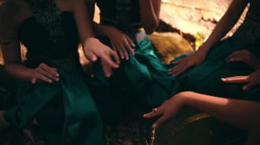 Asyalı bir kadının elleri, sabah köyün yakınlarında arkadaşlarıyla buluşurken ormanın içinde birlikte oturup gülerken.