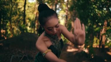 Balili kadın, köy festivali başlamadan önce yeşil bir elbise giyip ormanın içinde dans ediyor.