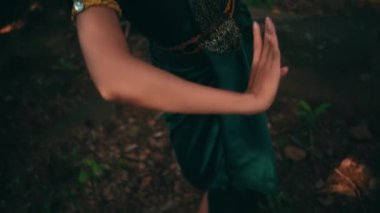 Balili kadın, köy festivali başlamadan önce yeşil bir elbise giyip ormanın içinde dans ediyor.