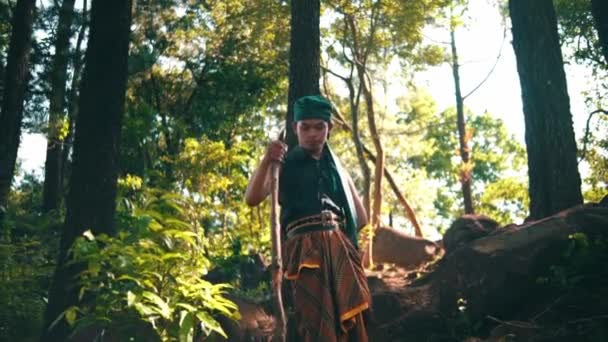 Asian Man Green Clothes Holding Stick While Walking Lonely Forest — Video
