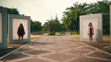 Bir grup Asyalı kadın ayrı ayrı duvarın önünde duruyorlar. Sabahları parkta korkunç ifadelerle.