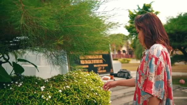 一个亚洲女人站在一棵盛满鲜花的植物前 早上她在花园里心烦意乱 情绪低落 — 图库视频影像