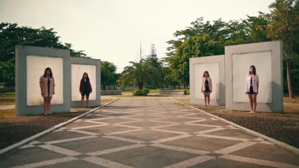 壁の前に立っているアジア系女性のグループです朝公園でとても怖い表情をしています — ストック動画