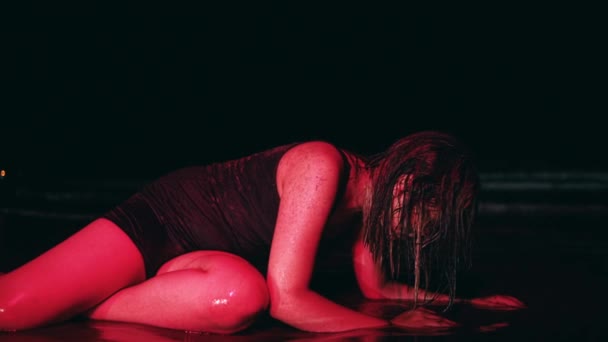 一个身穿黑色衣服 浑身湿透的亚洲女人 晚上躺在沙滩上 被波浪缠绕着 — 图库视频影像