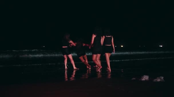 一群亚洲女人欺负她们的朋友 把她们拖到一片充满海水的海滩中央 直到晚上她们的身体都湿透了 — 图库视频影像