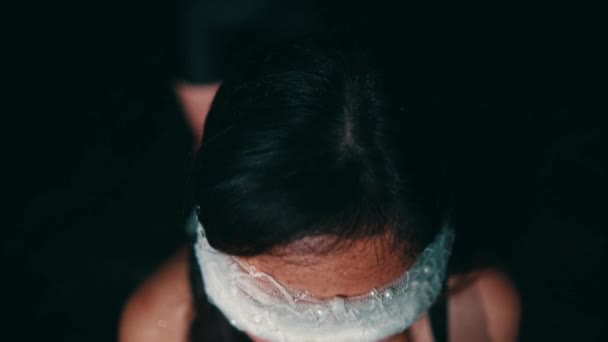 一个女人晚上一个人坐在沙滩上 手和眼睛都被白布捆着 — 图库视频影像