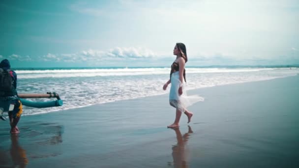 흰옷을 아시아 여자는 표정으로 해변을 뒤에는 파도가 밀려와 — 비디오