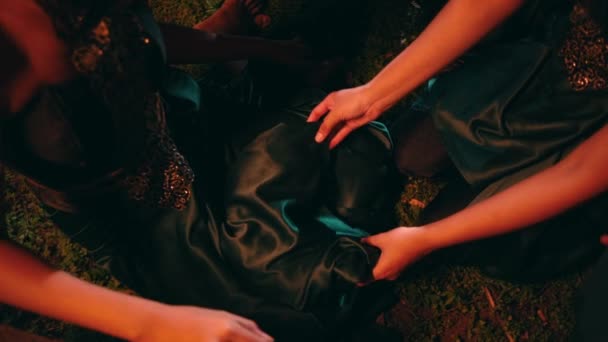 一群亚洲女人正在给深夜坐在森林中央的女人披上绿色的衣服 — 图库视频影像