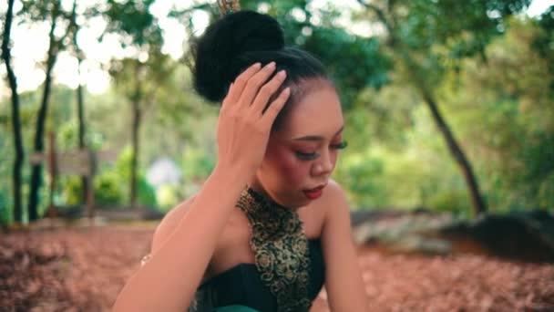 日中森の中で一人で泣きながら黒い髪を結ぶのが悲しいインドネシア人女性 — ストック動画