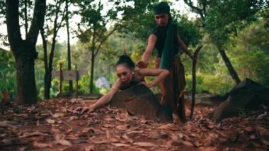 an Asian man steals apples from a helpless woman and lies on a rock in the middle of the forest in the morning