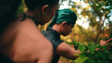 an Asian woman forbids a man to pick fruit in her garden in the morning