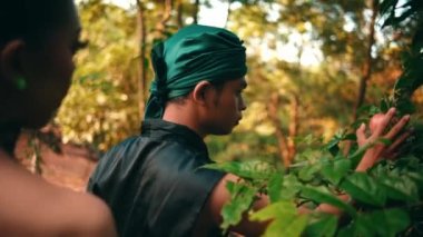 an Asian woman forbids a man to pick fruit in her garden in the morning