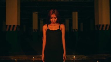 a woman in a black dress standing in the middle of a pentagram altar during a satanic revival in the middle of the dark at night