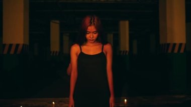 a woman in a black dress standing in the middle of a pentagram altar during a satanic revival in the middle of the dark at night