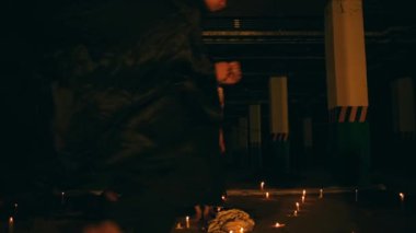 Sarışın ve siyah elbiseli bir kadın, gece yarısı pentagram mihrabında koşan adamlarla çevrili bir ayin büyüsü okuyor.