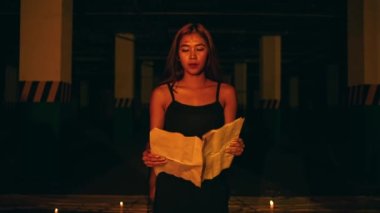 a woman with blonde hair and a black dress is chanting a satanic ritual in the middle of the altar at night