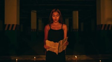 a woman with blonde hair and a black dress is chanting a satanic ritual in the middle of the altar at night