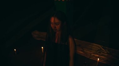 a woman combing the blonde hair of a Satanist in the background of the pentagram at night