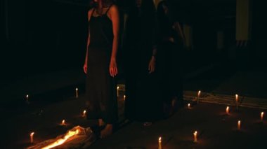 a group of satanic women perform a spirit summoning ritual in the middle of a satanic altar at night