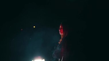 expressions of Satanists performing rituals in black clothes in the dark at night