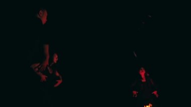 Bir grup satanist gecenin karanlığında şenlik ateşi etrafında dans edip ayinler yapıyorlar.