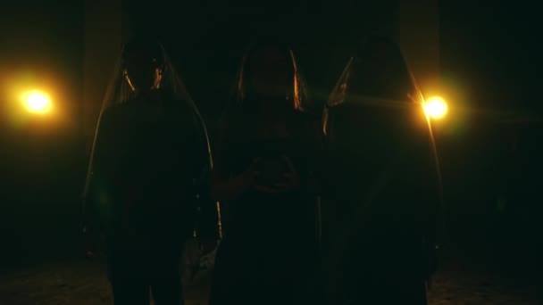 Grupp Djävulsdyrkare Svarta Kläder Går Tillsammans Mörkret Medan Utför Ritual — Stockvideo