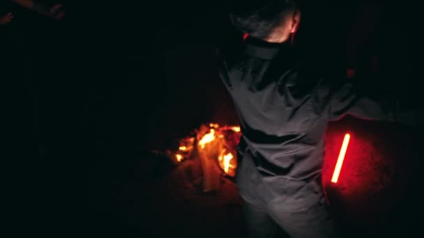 一群身穿黑衣的人在夜间的篝火边跳舞 — 图库视频影像
