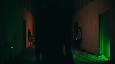 an Asian woman walking alone in the dark towards a club in the middle of the city at night