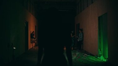 an Asian woman walking alone in the dark towards a club in the middle of the city at night