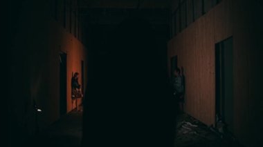 an Asian woman walking alone in the dark towards a club in the middle of the city at night