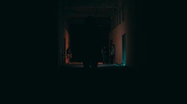 an Asian woman walking alone in the dark towards a club in the middle of the city at night