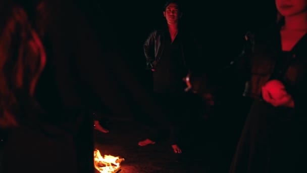 Bir Kadın Gece Kamp Ateşinin Önünde Kamp Yaparken Arkadaşlarına Elma — Stok video