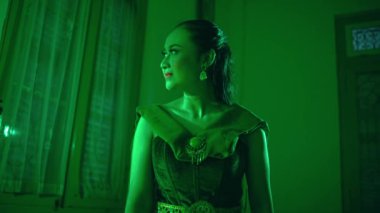 an Indonesian woman cries with regret that her friend bullied her for wearing a very sexy dress in a green room