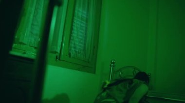 an Asian female dancer dancing in a very sexy dress in front of a mirror in a green room