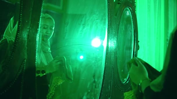 一位穆斯林妇女在一间晚上非常可怕的绿色房间里拿着一块神秘的绿色布 — 图库视频影像