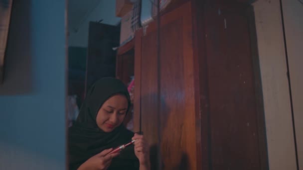 一名穆斯林妇女在离开前在镜子前化妆时 嘴唇上涂了口红 — 图库视频影像