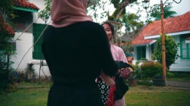 Bir grup Müslüman kadın sabahın köründe parkta birbirlerine hoş olmayan yüzlerle sarılıyorlar.