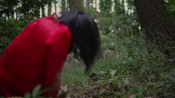 Азиатская Женщина Чувствует Боль Посреди Леса Надевая Утром Красную Рубашку — стоковое видео