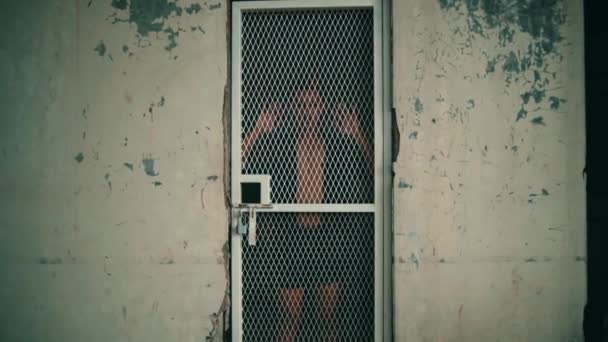 Ένας Ασιάτης Μαύρο Πουκάμισο Στέκεται Μπροστά Από Μια Κλειστή Πόρτα — Αρχείο Βίντεο
