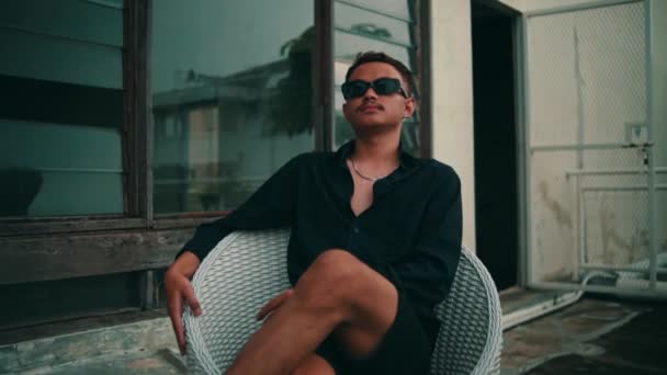 Porträtt Ung Asiatisk Man Med Solglasögon Sittande Stol Utomhus Medan — Stockvideo