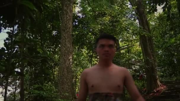 森の中のカメラを見ながら 裸の胸を持つ若いアジア人男性の肖像画 顔に集中しろ フィールドの浅い深さ — ストック動画