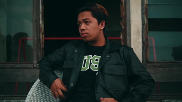 Portrait Jeune Homme Asiatique Dans Une Veste Noire Assis Sur — Video