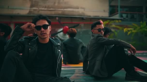 Młody Azjatycki Hipster Okularach Przeciwsłonecznych Siedzący Boisku Koszykówki Pozujący Razem — Wideo stockowe