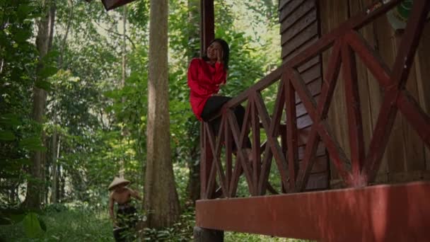 Молода Жінка Червоним Платтям Сидить Дерев Яному Паркані Під Час — стокове відео