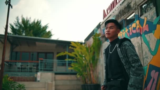 Asijský Muž Vzorovaném Županu Černých Kalhotách Stylově Pózuje Před Zdí — Stock video