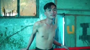 Asyalı çıplak bir adam, yeşil ışığı olan eski bir binada fotoğraf çekerken çok seksi duruyor.