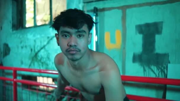 一个赤身裸体的亚洲男人站在一个有绿光的老楼里拍照时非常性感 — 图库视频影像